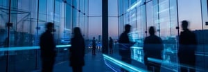 Silhouettes of people walking in front of glass walls